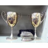 A pair of silver plated, twin handled pedestal trophy's, on stands  11"h overall; and a Ronson table