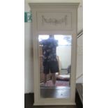 A modern mirror, the rectangular plate set in a terracotta painted and floral carved frame with a