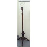 An early 20thC beech standard lamp with a turned, reeded column, on a carved tripod base  58"h