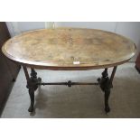 A late Victorian walnut and marquetry oval centre table, raised on opposing twin carved pillars,