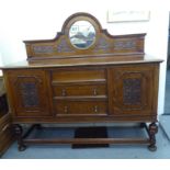 A 1920s oak sideboard with a mirrored panelled back, over two central drawers and another facsimile,