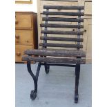 An early 20thC black painted scrolled wrought iron framed chair with a slatted wooden back and seat