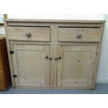 A late 19thC bleached pine side cabinet with two drawers, over two panelled doors, on a plinth  38"h
