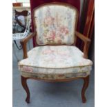 A modern French design carved beech framed open armchair with floral fabric upholstery and a
