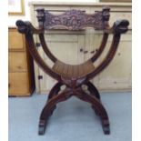 A 20thC Savonarola design lacquered mahogany framed chair with C-scrolled, foliate and mask carved