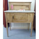 An Edwardian waxed pine washstand, the marble top over a pot cupboard door, raised on turned,