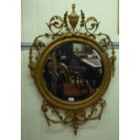 An early 20thC mirror, the circular bevelled plate  24"dia set in an Edwardian rococo design, gilded