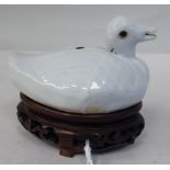 A Chinese off-white, porcelain model, a swimming duck  2"h on a carved hardwood stand