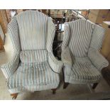 A matched pair of George III inspired patterned fabric upholstered wingback armchairs, raised on