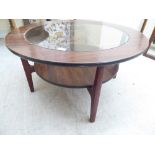 A 1970s/80s rosewood effect, two tier coffee table with an inset glass top, raised on tapered