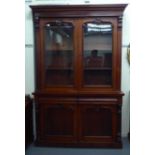 A late Victorian mahogany finished cabinet bookcase, the upper section with a pair of glazed