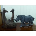 A composition stone model Rhino  11"h; and a carved wooden giraffe group  16"h