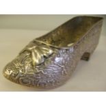 A Dutch silver coloured metal ornament, in the form of a lady's shoe, allover cast and chased with