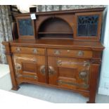 An early 20thC honey coloured oak dresser, in the manner of Liberty with stylised copper handles,