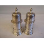 A pair of tower design pepper pots with applied wire bands, domed, perorated covers on bayonet