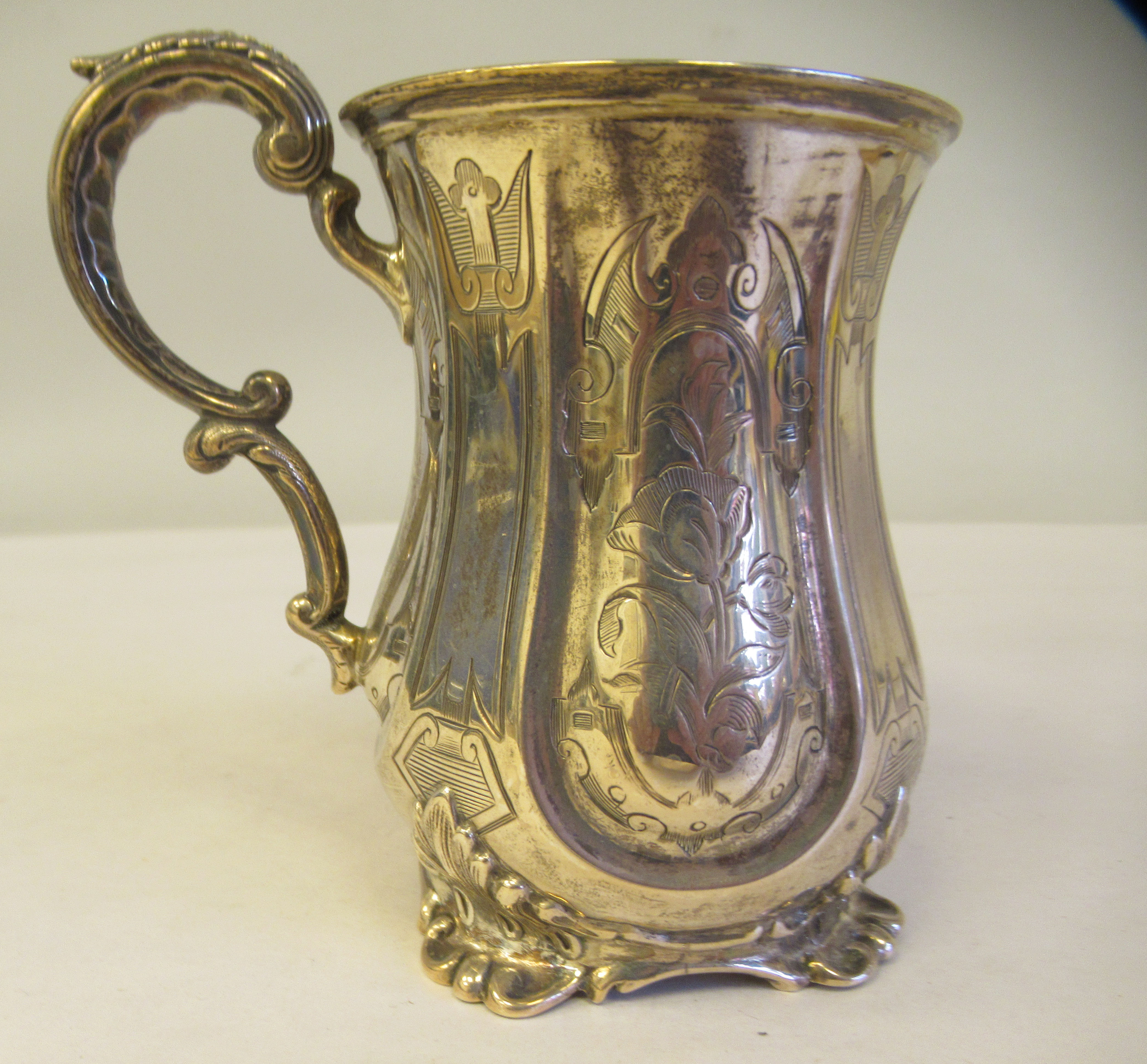 A mid Victorian silver Christening mug of waisted form with a double C-scrolled handle and bright