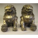 A pair of late 19th/early20thC Chinese white metal models, seated Dogs of Fo with traditionally cast