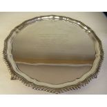 A Georgian silver salver with a raised and gadrooned piecrust border, elevated on talon and ball