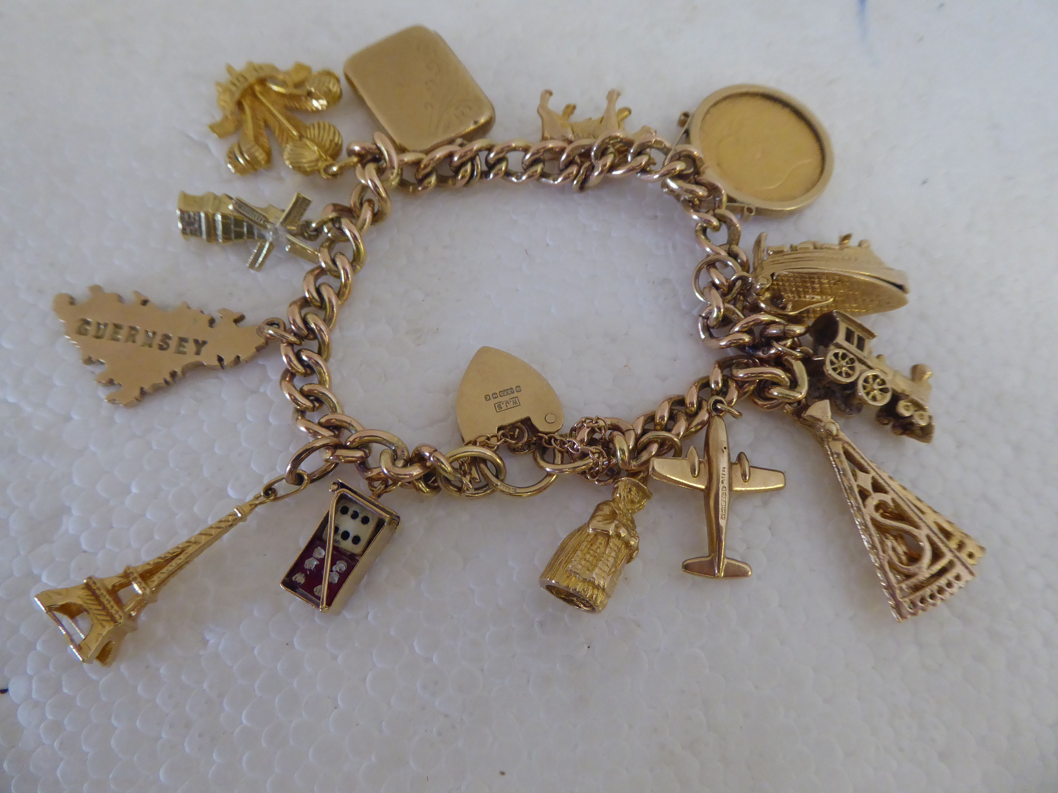 A 9ct gold bracelet with eleven 9ct gold and yellow metal charms; and an Edward VII half-