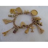 A 9ct gold bracelet with eleven 9ct gold and yellow metal charms; and an Edward VII half-