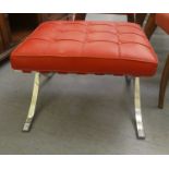 A Barcelona style footstool with a stitched and button upholstered red hide top over a chromium