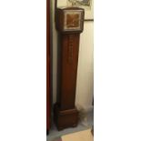 A 1930s oak cased granddaughter clock; the movement faced by a Roman dial  56"h