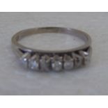 An 18ct white gold, claw set, seven stone diamond ring