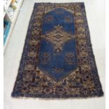 A Persian rug with stylised decoration on a blue ground  86" x 48"