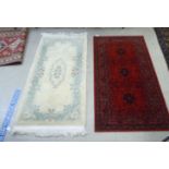 Two rugs, viz. a Chinese mat  29" x 64"; and a Royal Kashan Afghan rug, on a red ground  33" x 62"