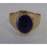 An 18ct gold signet ring with an engraved shank, set with a blue stone