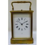 A mid 20thC brass cased carriage clock with bevelled glass panels and a folding top handle, on a