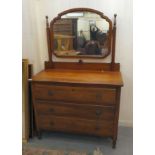 An early/mid 20thC mahogany three drawer dressing table, surmounted by a mirror, raised on turned