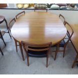 A Rosengaarden CJ teak dining table, raised on turned legs  29"h  50"dia to 88"dia with two