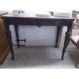 A 1930s oak hall table, raised on carved, turned, fluted, tapered legs and casters  31"h  38"w