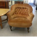 A late Victorian tub design salon chair with a brown fabric, button upholstered back, raised on