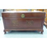 A mid 20thC Chinese camphorwood chest with a hinged lid and a panelled front, raised on bracket feet