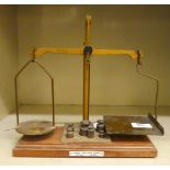A set of precision brass balance scales with attendant weights, on a platform  9"w
