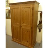 A modern waxed pine wardrobe with two full height panelled doors, on a plinth  77"h  43"w