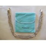 A Tiffany & Co silver and gold coloured metal multi-strand necklace with hook clasps and a fabric