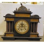 A late Victorian black slate cased mantel clock of architectural form, on a plinth; the movement
