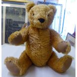 A golden plush Teddy bear with mobile limbs  10"h