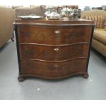 A modern walnut veneered three drawer serpentine front dressing chest, raised on bun feet  30"h