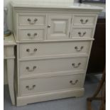 A modern cream painted dressing chest with four short drawers, a cupboard door and three long