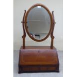 An Edwardian string inlaid mahogany dressing table mirror, the oval plate pivoting on horns, over