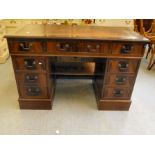 A modern mahogany finished nine drawer twin pedestal desk, the top set with a tooled brown hide