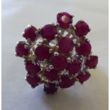 A silver coloured metal ruby cluster ring