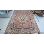 An Indian rug, decorated with a central motif, diamond formations and bordered by foliage designs,