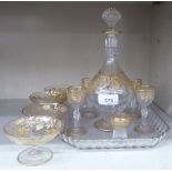 A late 19thC matched glass liqueur set, decorated with engraved and gilded flora  10"h