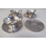 A set of three engine turned silver plated tea cups and four saucers