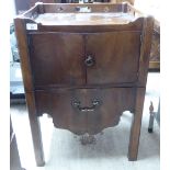 A George III mahogany nightstand with a galleried border, two doors and a deep drawer, raised on